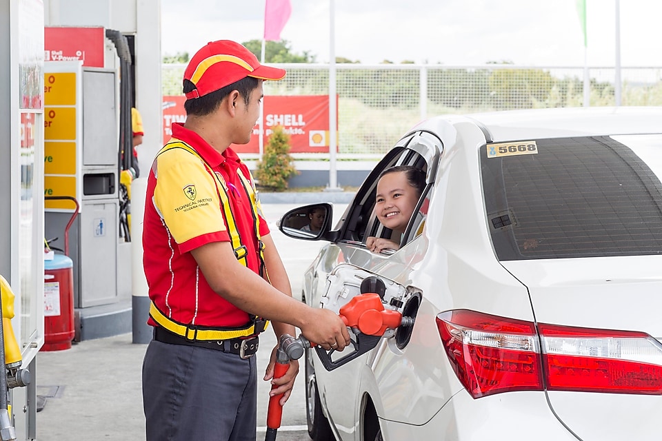 pump attendant filling the car with petrol nozzle