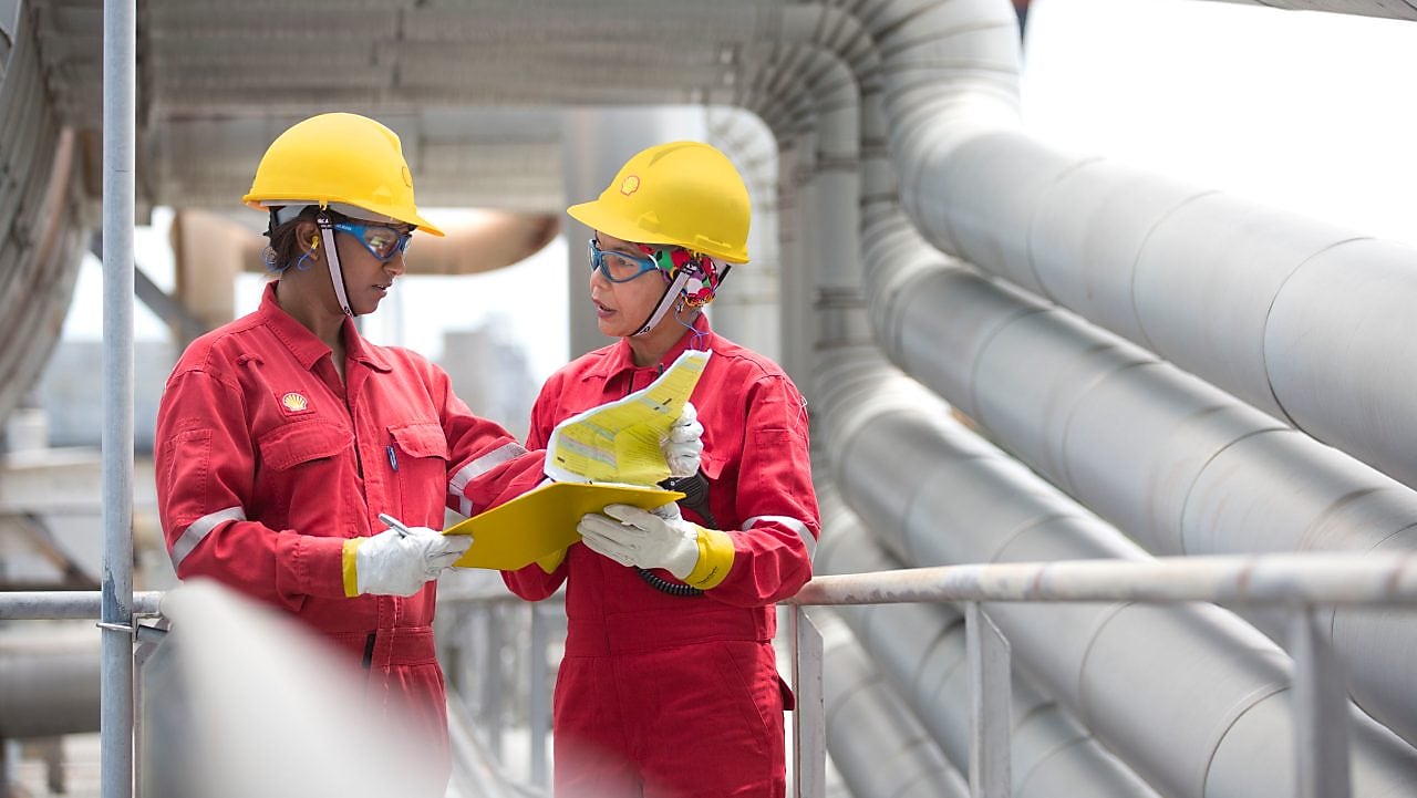 two workers discussing a project in a refinery in Malaysia, Bintulu ATl, rercuitment, Malaysia 2013