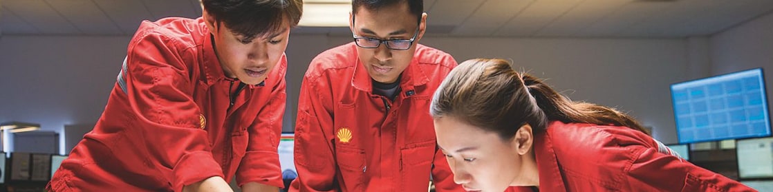 Three people looking at plans