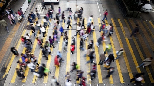 People cross a busy street in Hong Kong