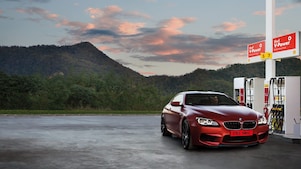 Red car in shell forecourt