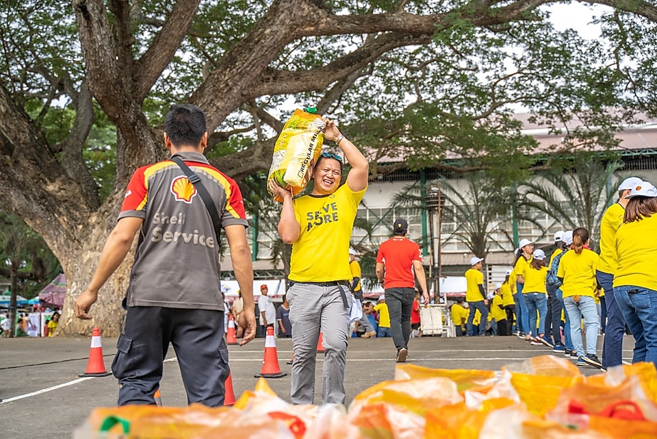 Shell ACTS volunteers form an assembly line to ensure that the relief packs, hygiene kits, and potable drinking water are delivered to the evacuation sites in Batangas. 