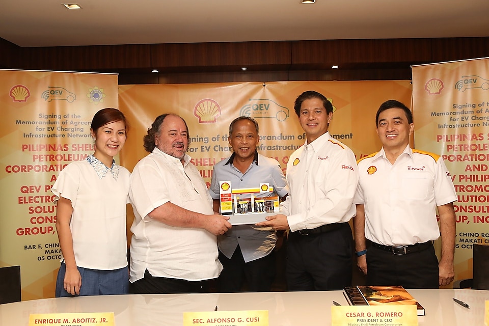 Endika Aboitiz (2nd from left), President of QEV Philippines Electromobility Solutions and Consulting Group, Inc., accepts a miniature replica of a Shell retail station from Cesar Romero, President and CEO of PSPC