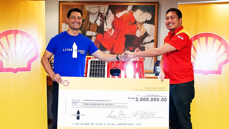 Mark Malabanan, Shell V-Power Brand Manager, shakes hands with Illac Diaz, Liter of Light Founder and Executive Director