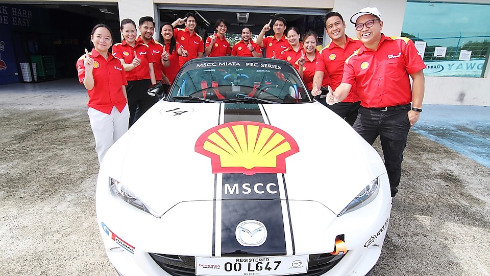 Shell employees posing with car