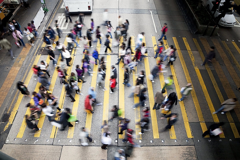 People cross a busy street in Hong Kong
