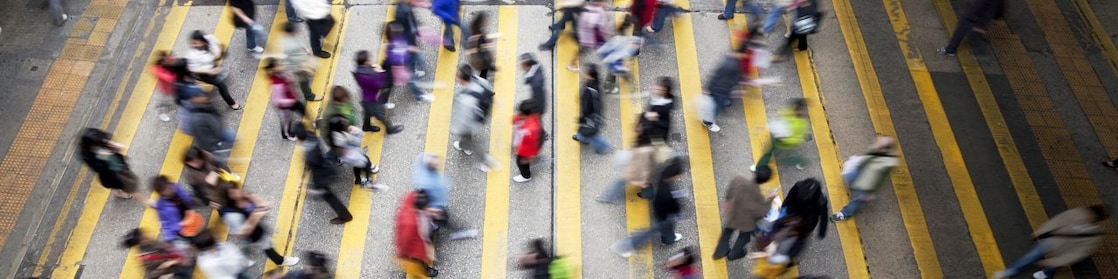People cross a busy street in Hong Kong