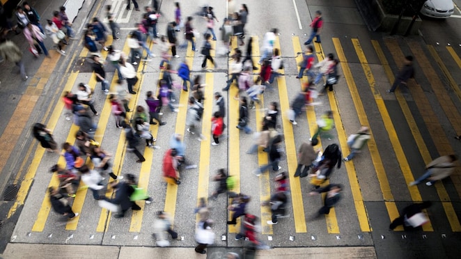People cross a busy street in Hong Kong
