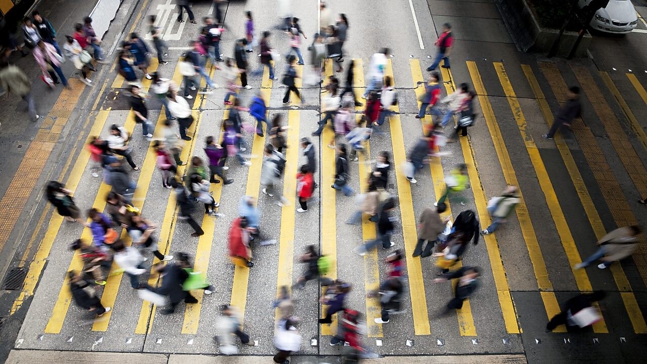 People cross a busy street in Hong Kong