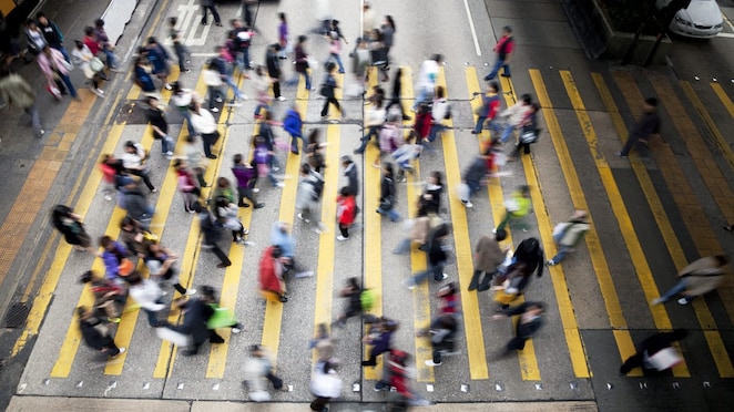 People cross a busy street in Hong Kong