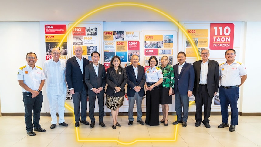 Group photo of Shell Pilipinas officers in front of a backdrop showcasing the highlights of 110 years of Shell Pilipinas.