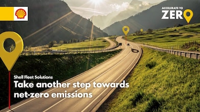 The sun is shining on a wide road with lush green surroundings, with yellow map pins along the way.